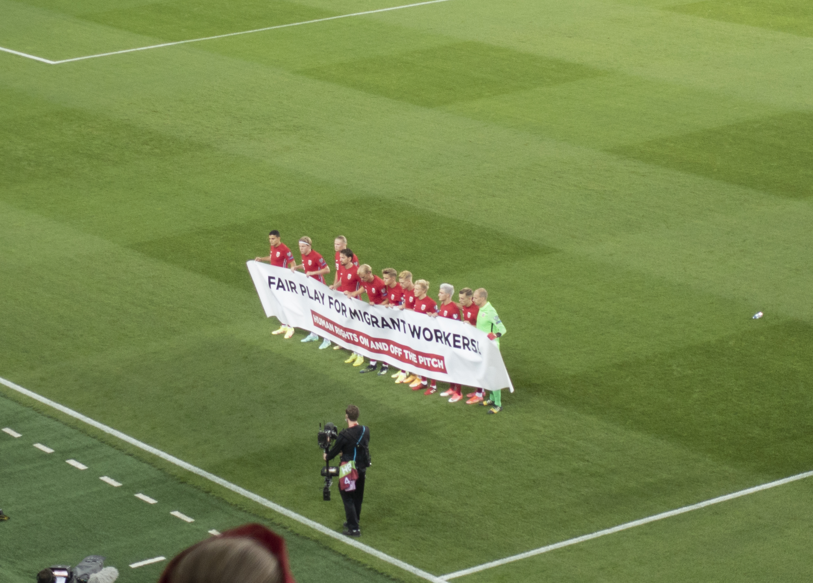 Bildet viser det norske fotballandslaget med et banner med støtte til menneskerettighetene