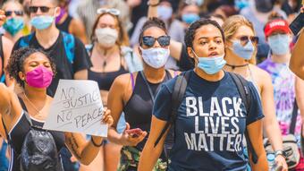 Folkemengde demonstrerer mot rasisme i USA. Kvinner og menn med "Black Lives Matter"-t-skjorter. Flere har på munnbinn for beskyttelse mot covid-19.