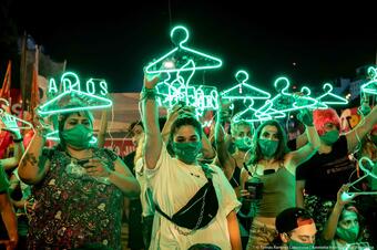Kvinner holder opp lysende kleshengere i Argentina. 
