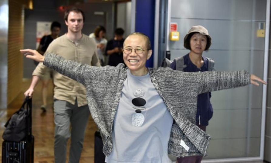 Liu Xia slår ut armene og smiler på flyplassen i Berlin. 