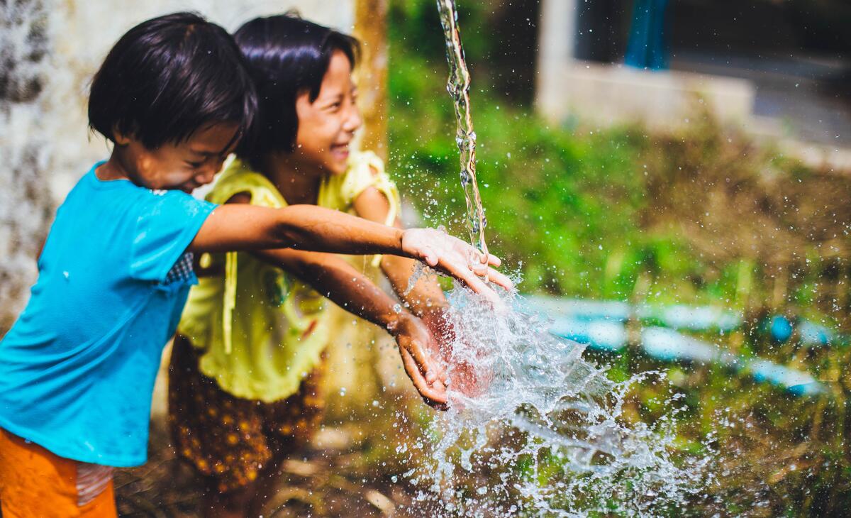 To barn leker med vann. 