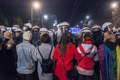 Kvinne demonstrerer i gaten i Polen. Politiet står foran dem. 