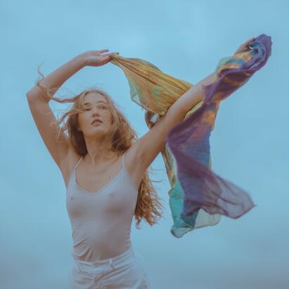 Bildet viser en ung kvinne dansende med et sjal