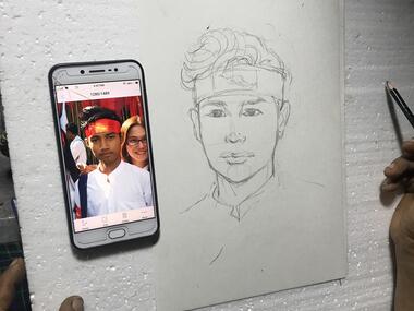 Mobil viser portrett av en ung mann, og ligger ved siden av en tegning av portrettet