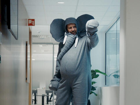 Mann kledd som elefant danser i kontorlokale