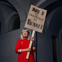 Eva Bratholm holder en parole med teksten "Nei til undertrykkelse av kvinner"